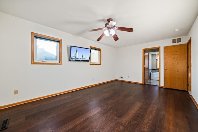 unfurnished room with visible vents, baseboards, dark wood-type flooring, and a ceiling fan