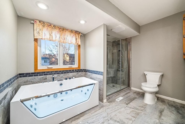 bathroom featuring baseboards, toilet, a jetted tub, and a shower stall