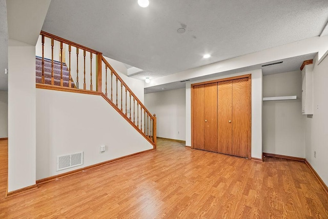 interior space with stairway, wood finished floors, visible vents, baseboards, and recessed lighting