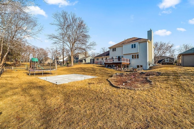 view of yard featuring a playground, a trampoline, a patio area, and a wooden deck