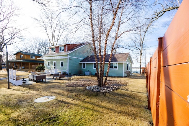 rear view of property featuring a lawn