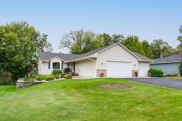 single story home with aphalt driveway, stone siding, an attached garage, and a front yard