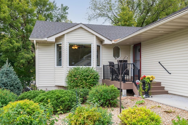 entrance to property featuring roof with shingles