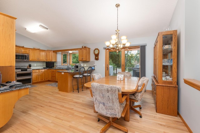 dining space with lofted ceiling, a notable chandelier, a healthy amount of sunlight, and light wood-type flooring