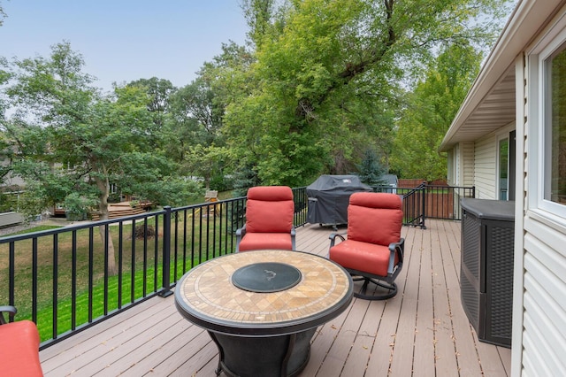 wooden terrace featuring a yard and a grill