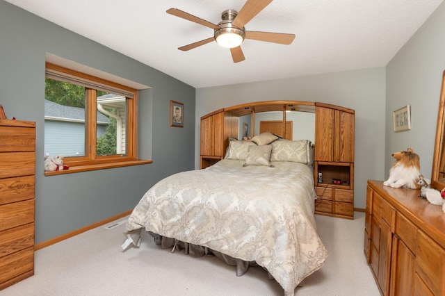 bedroom with light carpet, visible vents, ceiling fan, and baseboards