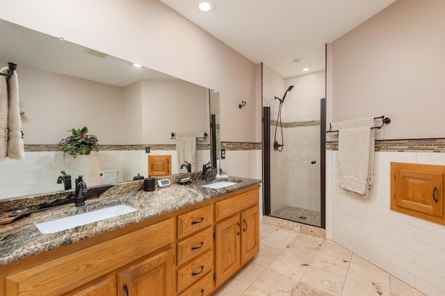 bathroom featuring tile walls, a stall shower, and a sink