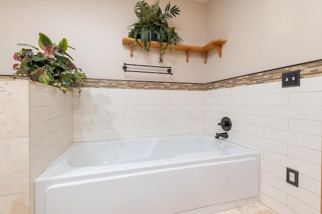 full bathroom with tile patterned flooring, tile walls, and a bath