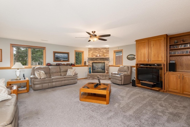 carpeted living room with a brick fireplace and ceiling fan