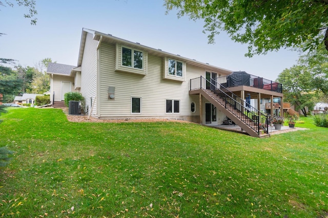 rear view of house with central AC unit, a wooden deck, stairs, and a yard