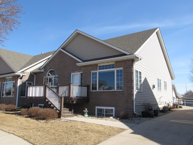 view of front of house featuring brick siding and a wooden deck