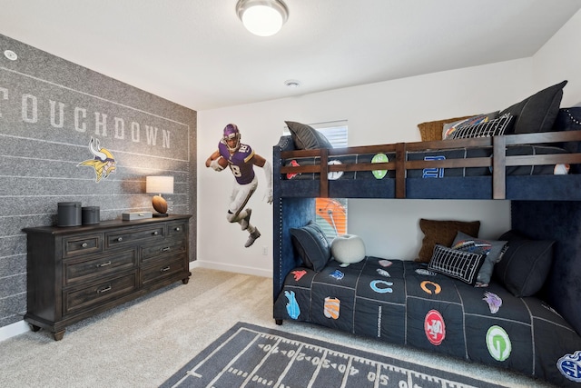 bedroom featuring an accent wall, baseboards, and carpet floors