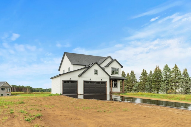 view of front of house with a garage, a water view, and board and batten siding