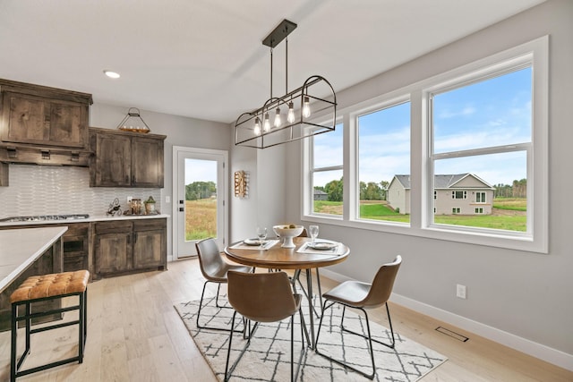 dining room featuring recessed lighting, baseboards, plenty of natural light, and light wood finished floors