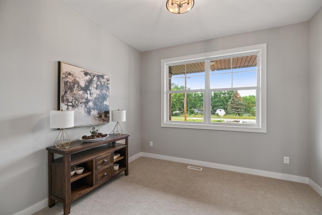 interior space featuring visible vents, baseboards, and light colored carpet