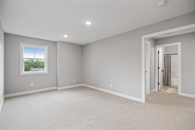 empty room featuring recessed lighting, light colored carpet, visible vents, and baseboards