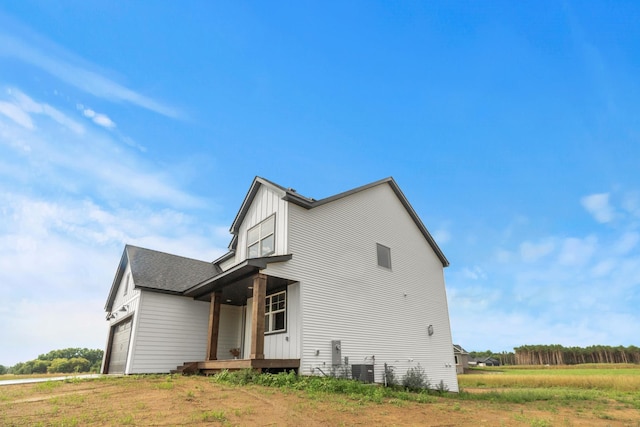 view of home's exterior featuring roof with shingles, board and batten siding, and an attached garage