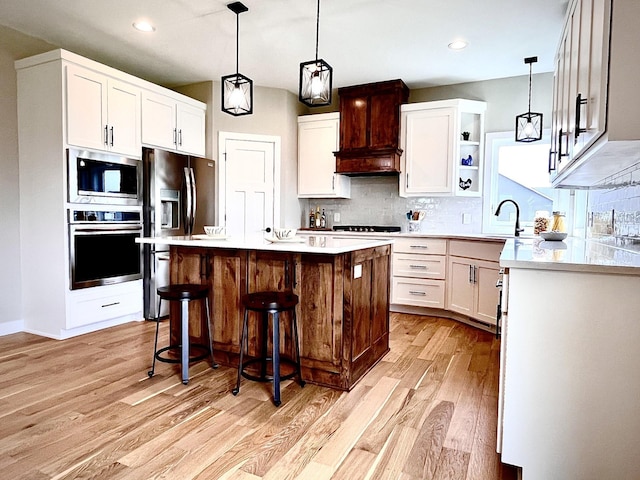 9551 230th St E, Lakeville, MN 55044 - kitchen with appliances with stainless steel finishes, light wood finished floors, light countertops, tasteful backsplash, and recessed lighting