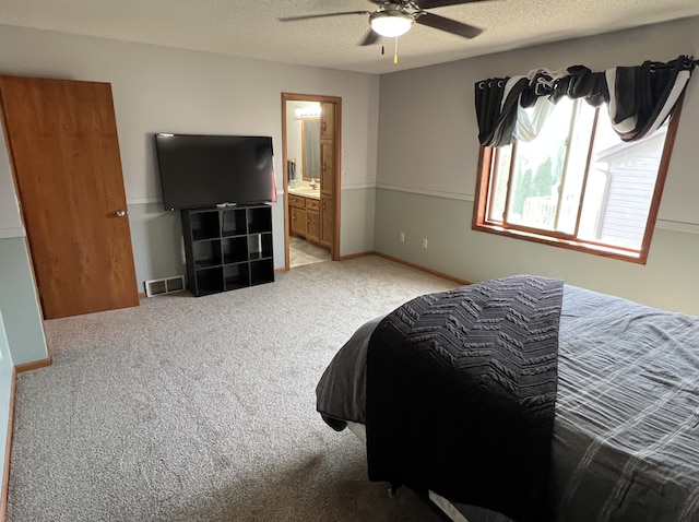 carpeted bedroom with a textured ceiling, ceiling fan, visible vents, and connected bathroom