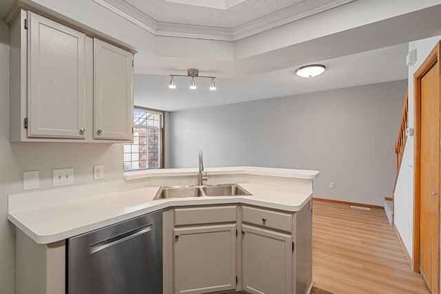 kitchen with a sink, a textured ceiling, dishwasher, and a peninsula