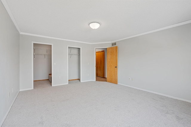 unfurnished bedroom with visible vents, carpet floors, baseboards, and ornamental molding