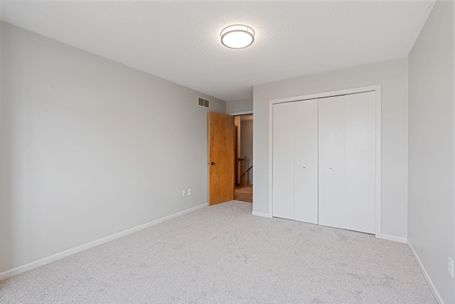 unfurnished bedroom featuring visible vents, baseboards, a closet, and carpet floors