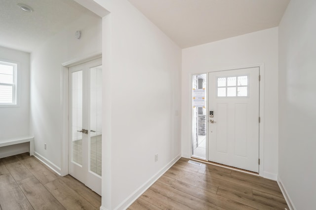 foyer featuring baseboards and light wood-style floors