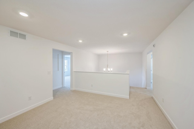 spare room with visible vents, baseboards, a chandelier, light carpet, and recessed lighting