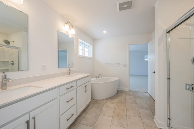 full bath featuring visible vents, a freestanding tub, a stall shower, and a sink