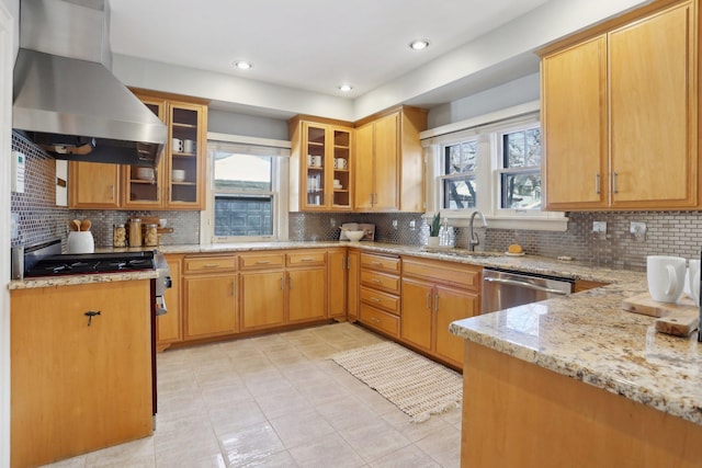 kitchen featuring a wealth of natural light, island exhaust hood, light stone counters, a sink, and appliances with stainless steel finishes