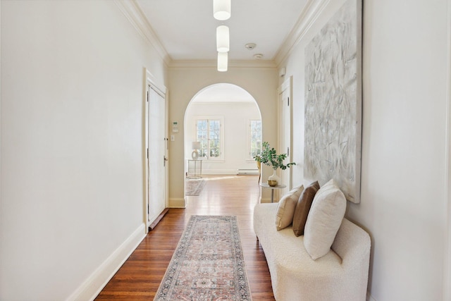 hall featuring baseboards, dark wood finished floors, arched walkways, ornamental molding, and a baseboard heating unit