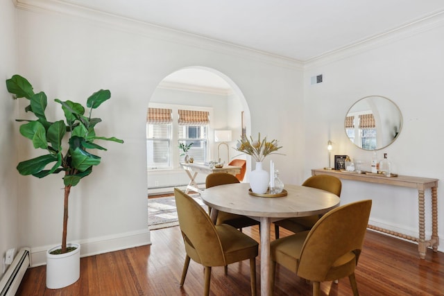 dining area featuring visible vents, ornamental molding, wood finished floors, arched walkways, and a baseboard radiator