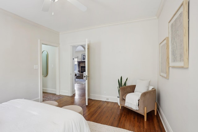 bedroom with a ceiling fan, crown molding, baseboards, and wood finished floors