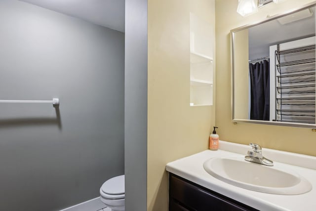 full bathroom with vanity, toilet, and baseboards