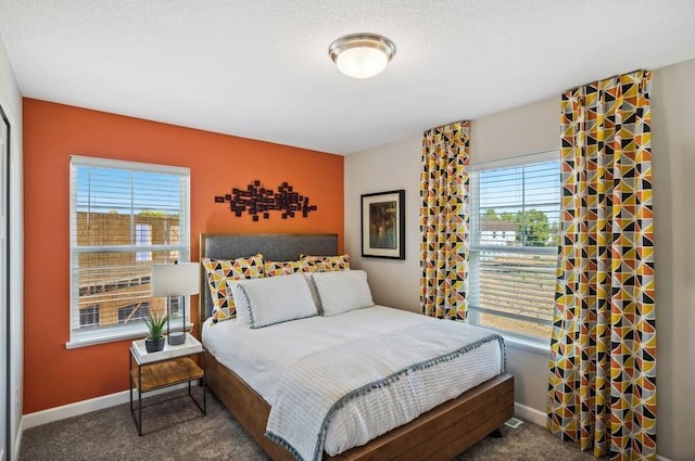 bedroom featuring baseboards, multiple windows, and carpet