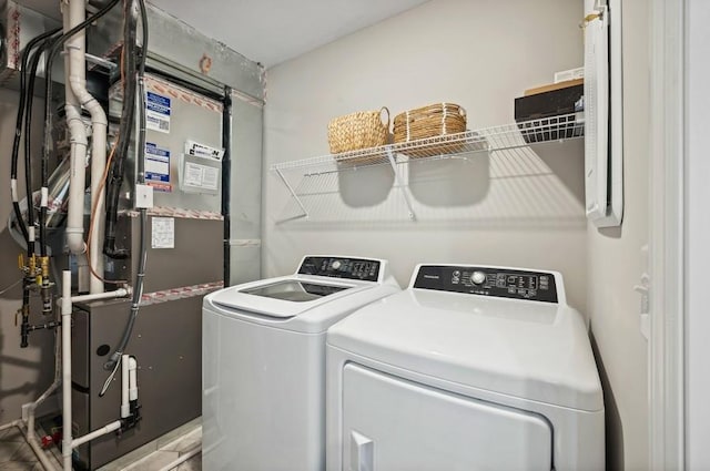 washroom with washer and dryer, heating unit, and laundry area