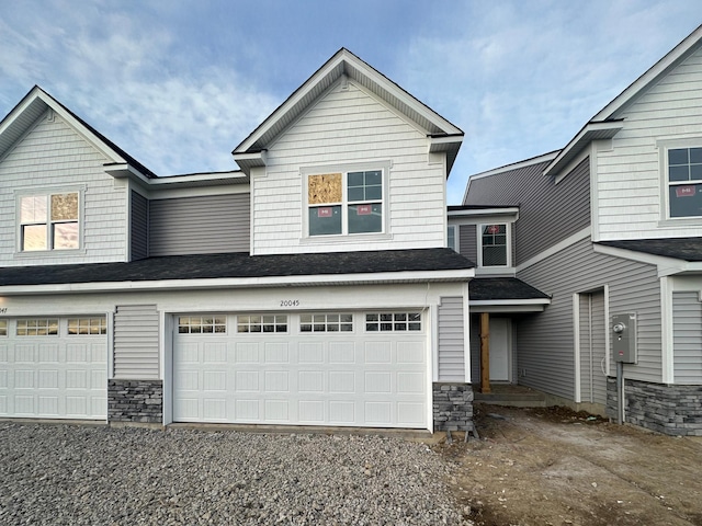 view of front of home with stone siding, driveway, and a garage