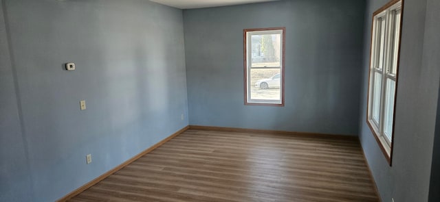 empty room with baseboards and wood finished floors