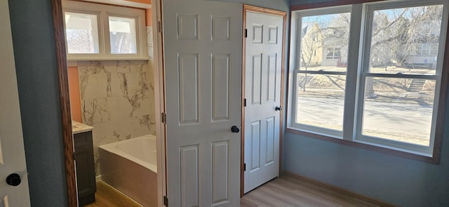 interior space with baseboards, plenty of natural light, and light wood-style floors