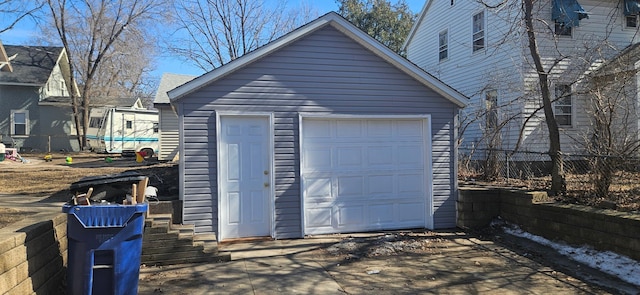 detached garage featuring fence and driveway