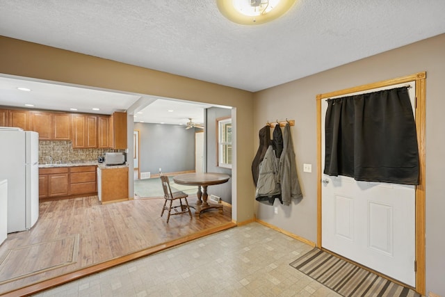 foyer with recessed lighting, baseboards, and a textured ceiling