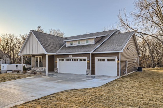 view of front of house with central air condition unit, an attached garage, driveway, and roof with shingles