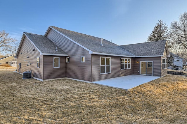 rear view of house with a yard, a patio, roof with shingles, and central AC