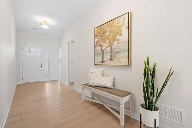 foyer with baseboards, visible vents, and light wood finished floors