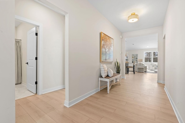 hallway with baseboards and light wood-style flooring