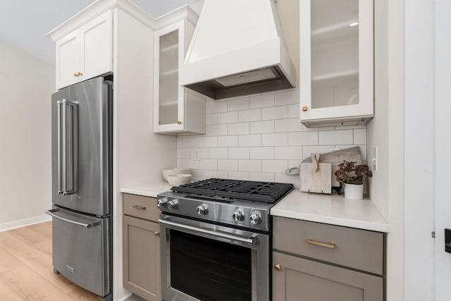 kitchen with premium range hood, stainless steel appliances, tasteful backsplash, and gray cabinets