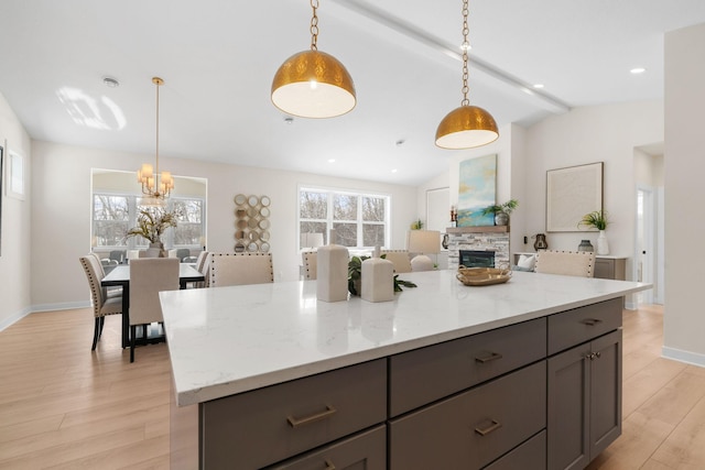 kitchen with plenty of natural light, gray cabinets, vaulted ceiling with beams, and light wood-type flooring