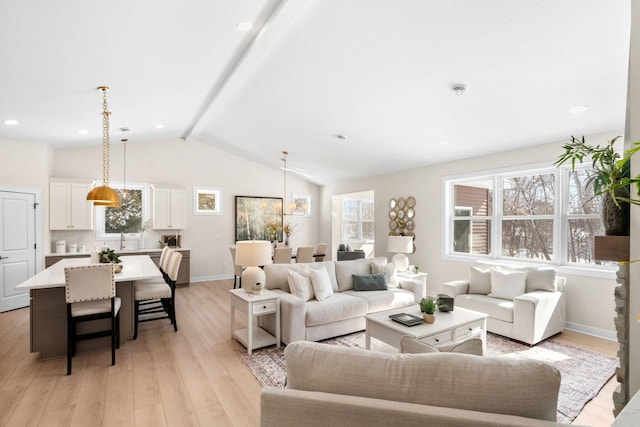 living room with lofted ceiling with beams, light wood-style floors, baseboards, and a wealth of natural light