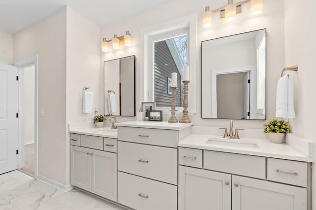 full bathroom with two vanities, baseboards, marble finish floor, and a sink