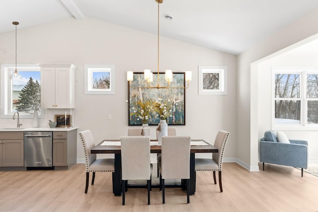 dining room featuring light wood finished floors, vaulted ceiling with beams, and plenty of natural light